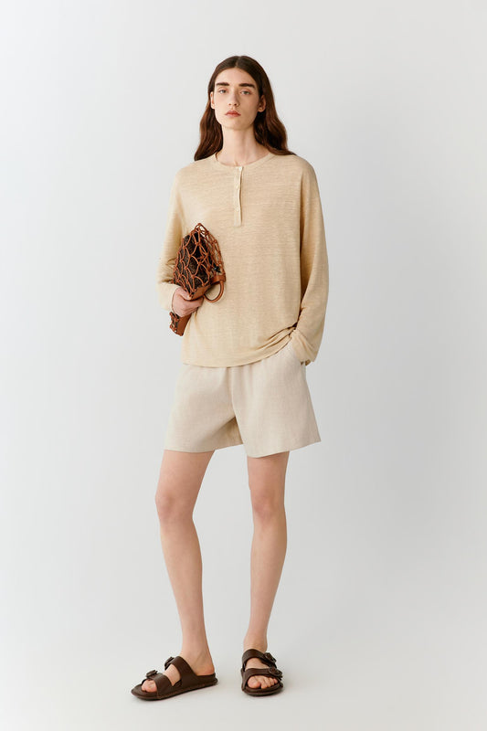 Full-length view showing the top paired with matching shorts. The image emphasizes the soft movement of the lightweight linen blend jersey, the relaxed proportions and the effortless drape of the silhouette.