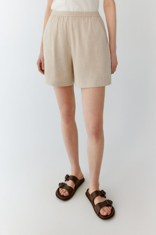 Full-length view focused on the shorts, emphasizing the relaxed fit, above-the-knee length and soft movement of the lightweight linen and viscose blend. The image highlights the fluid silhouette and comfortable proportions.