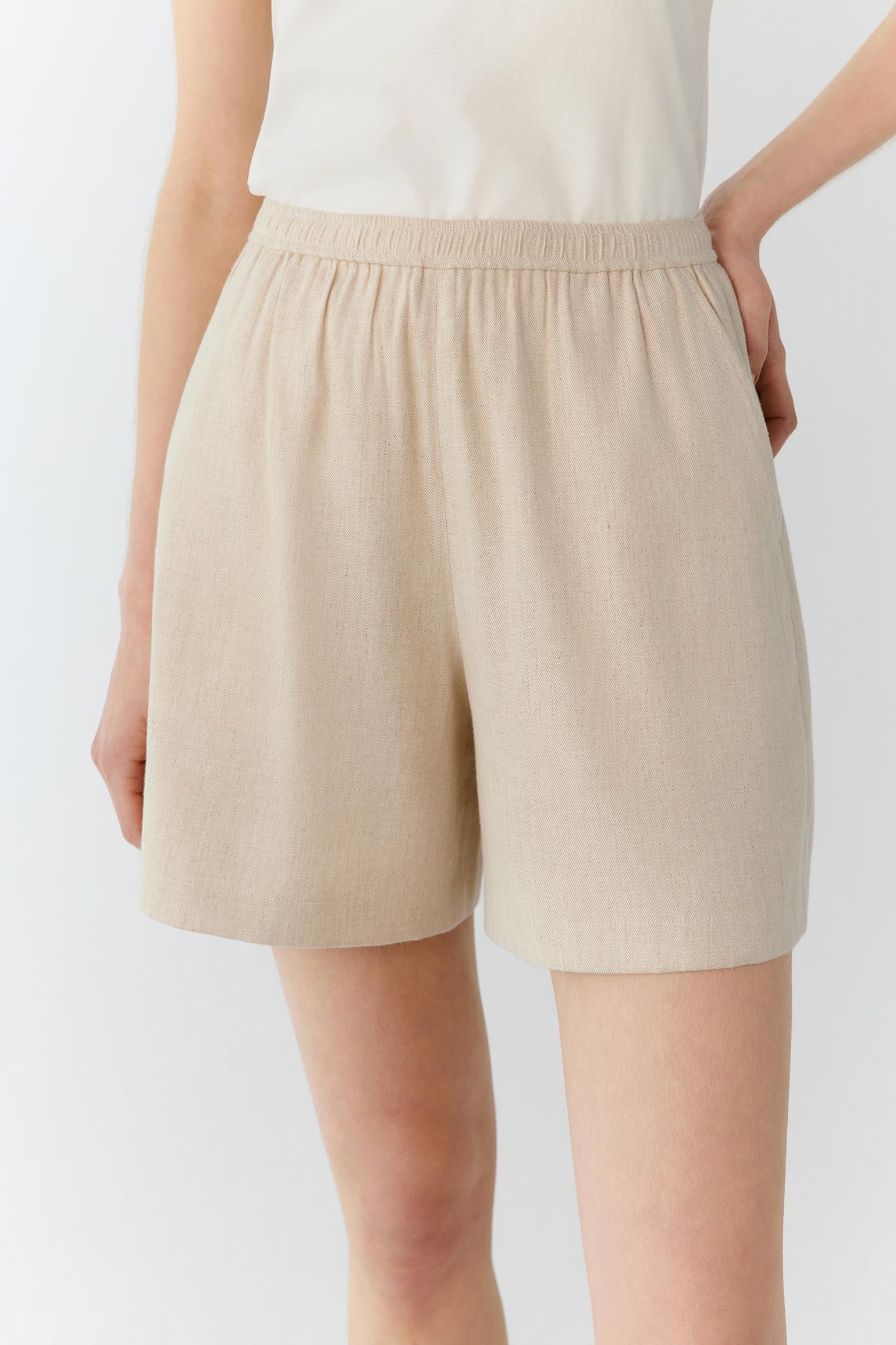 Front view highlighting the relaxed cut, fluid drape and lightweight structure of the fabric. The image emphasizes the clean side seam and the natural movement of the shorts when worn.