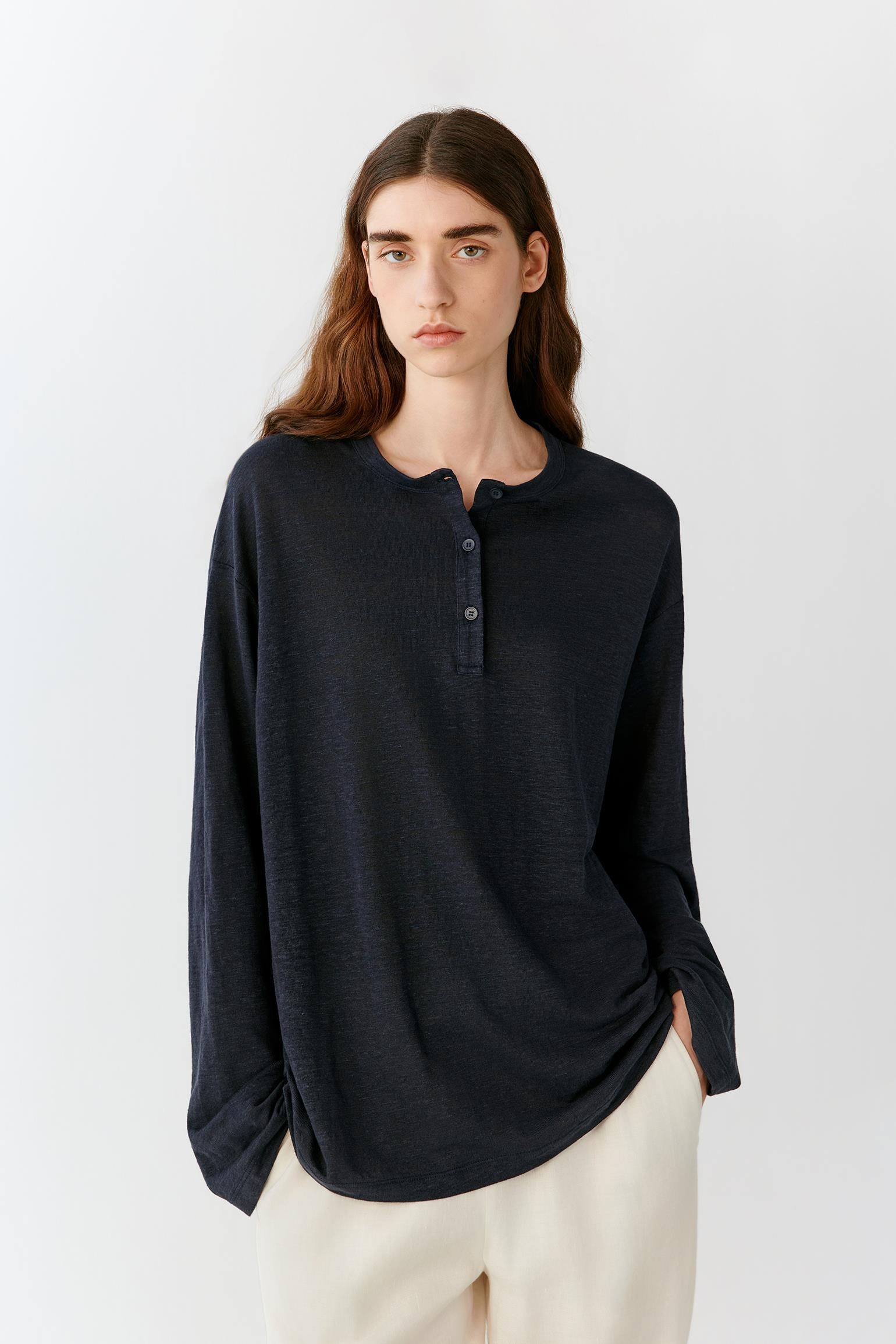 Front view showing the soft volume of the top and the natural movement of the lightweight linen blend jersey. The image emphasizes the relaxed fit, long sleeves and fluid silhouette that falls effortlessly over the body.