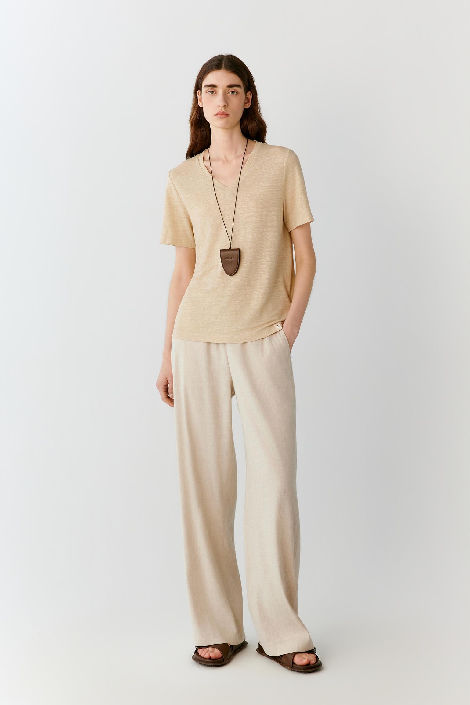 Full-length view showing the top paired with coordinating wide-leg trousers. The image emphasizes the easy proportions, fluid drape and lightweight character of the linen blend jersey, illustrating the relaxed silhouette from shoulder to hem.