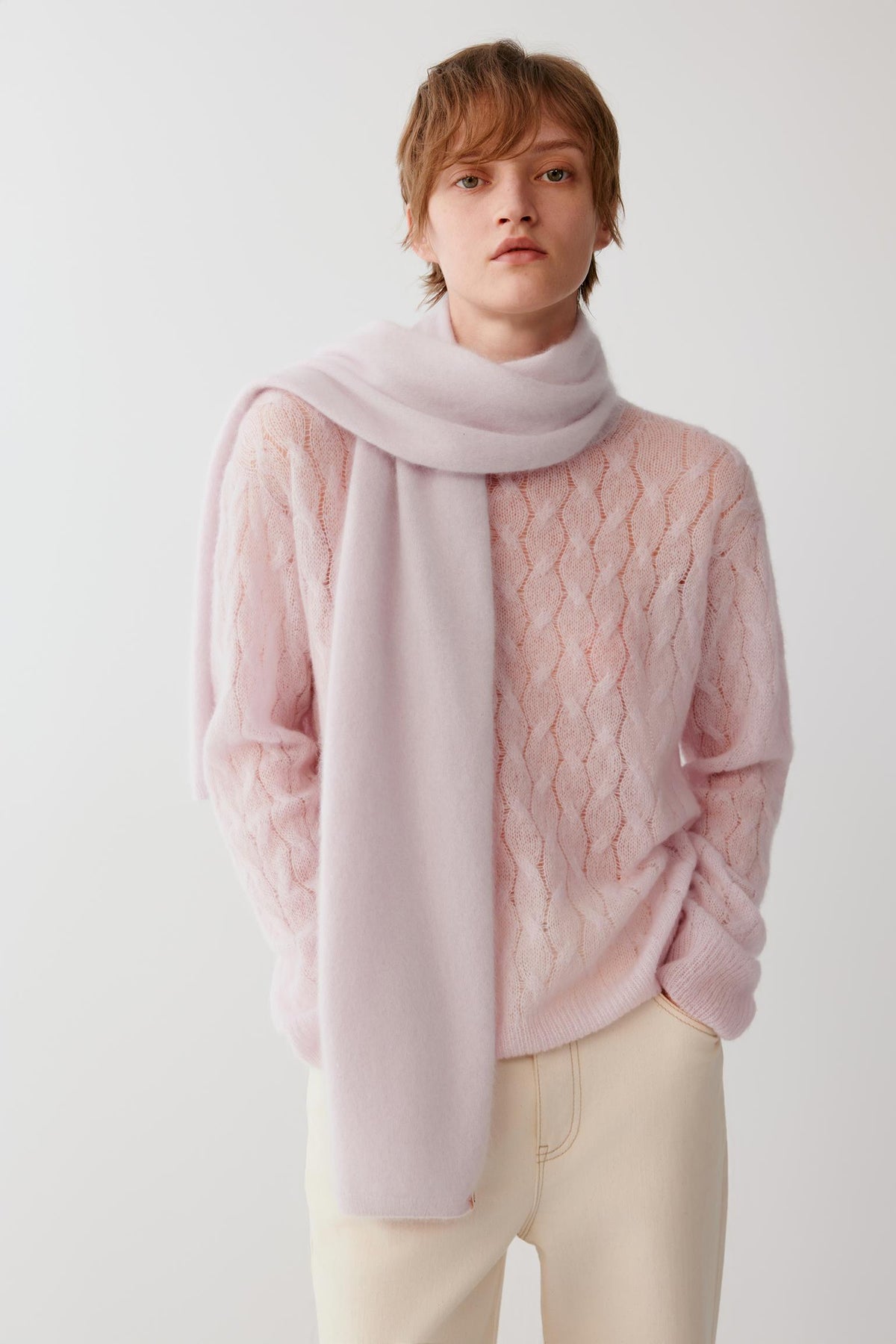 Front view of a woman wearing the light pink brushed cashmere scarf, highlighting its long shape and soft drape.
