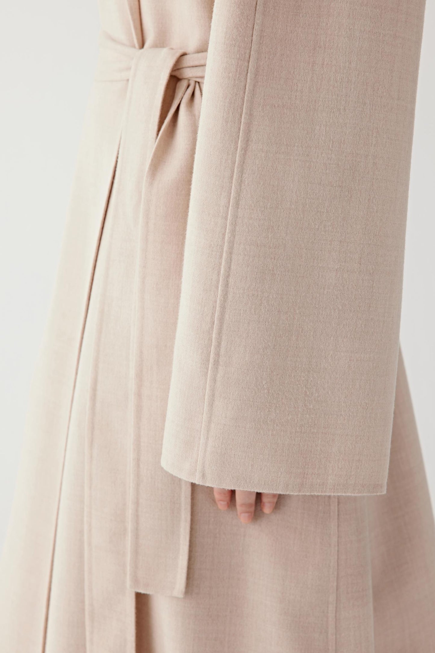 Detail of the self-tie belt defining the waist.