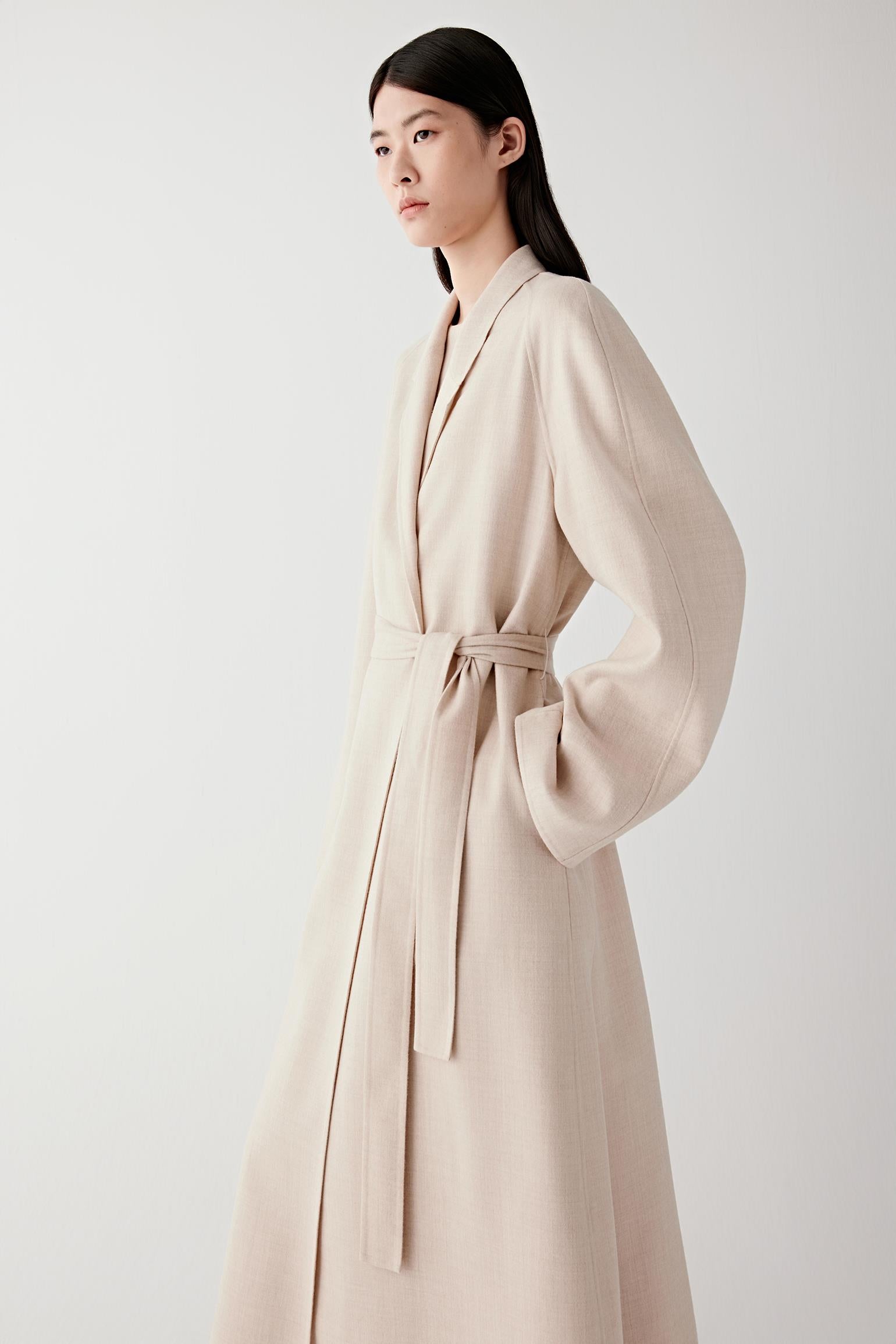 Side view of the coat showing its fluid drape and mid-calf length.