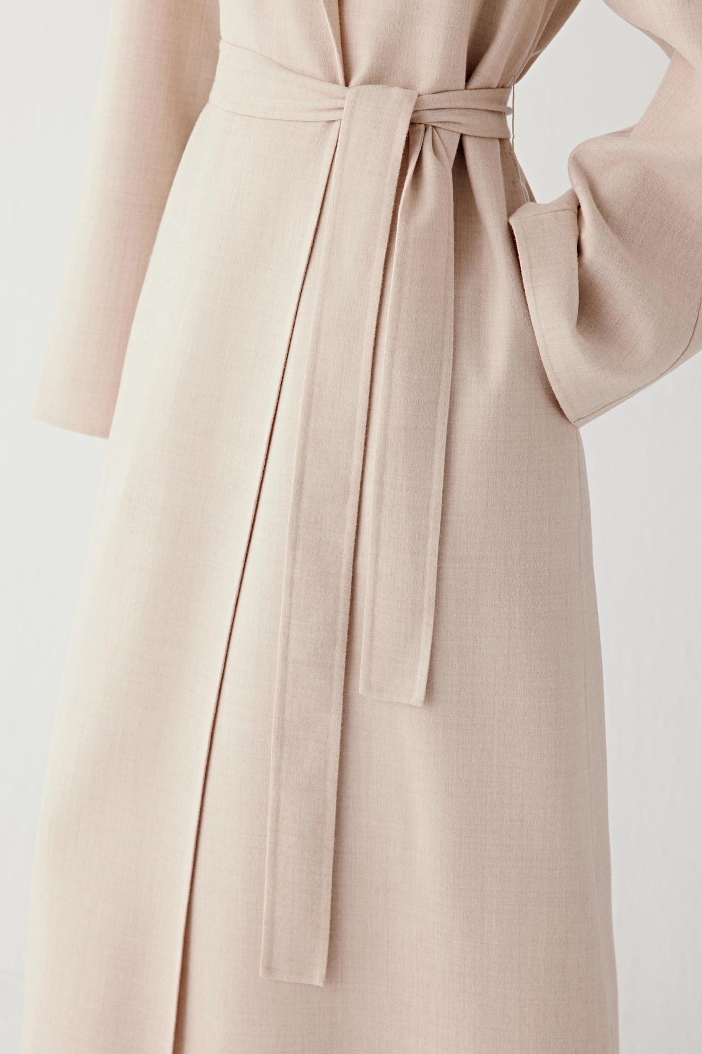 Detail of the self-tie belt defining the waist.