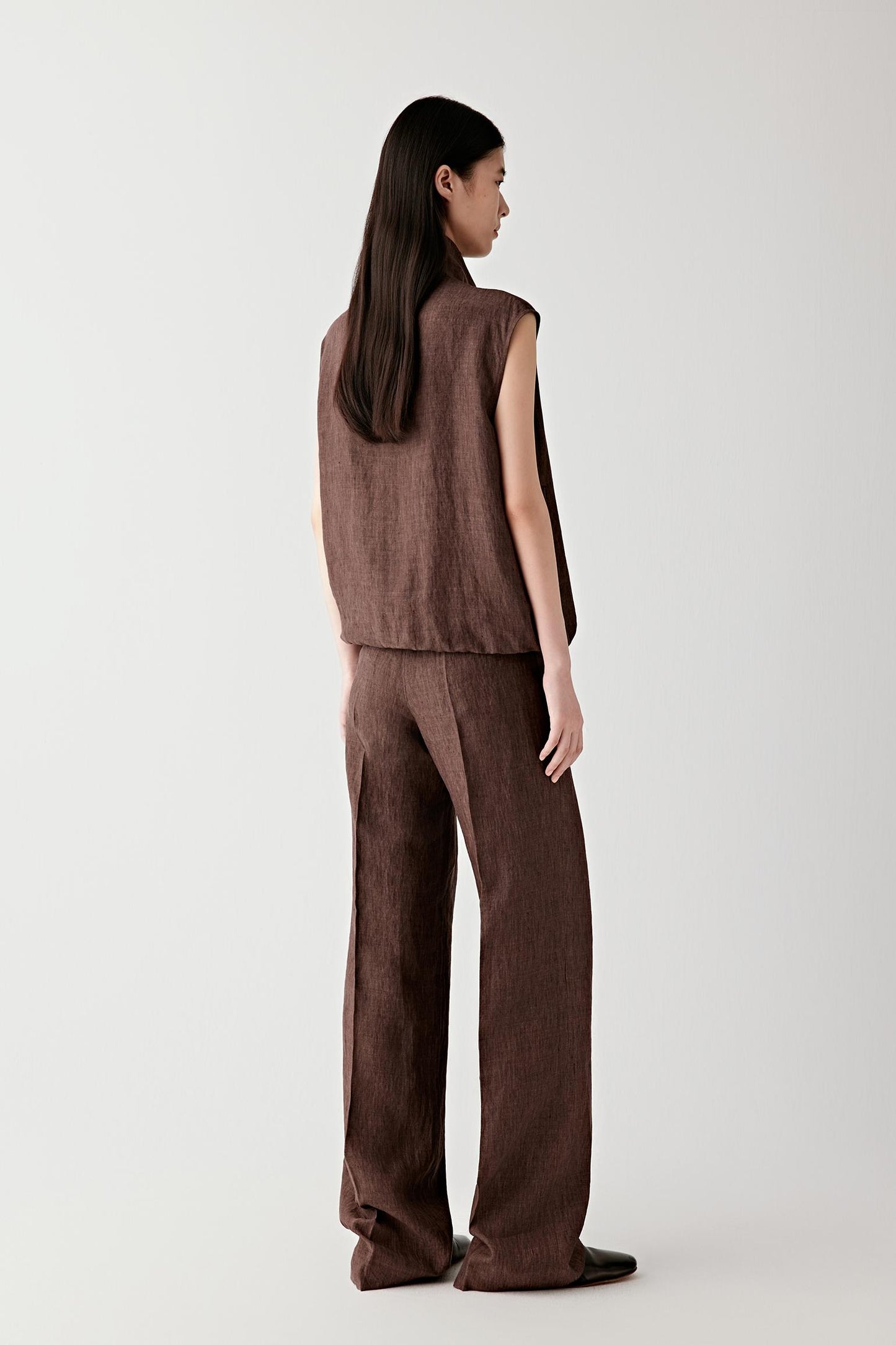 Side view showing the sleeveless construction, armhole shape and how the vest follows the contours of the body while maintaining structure