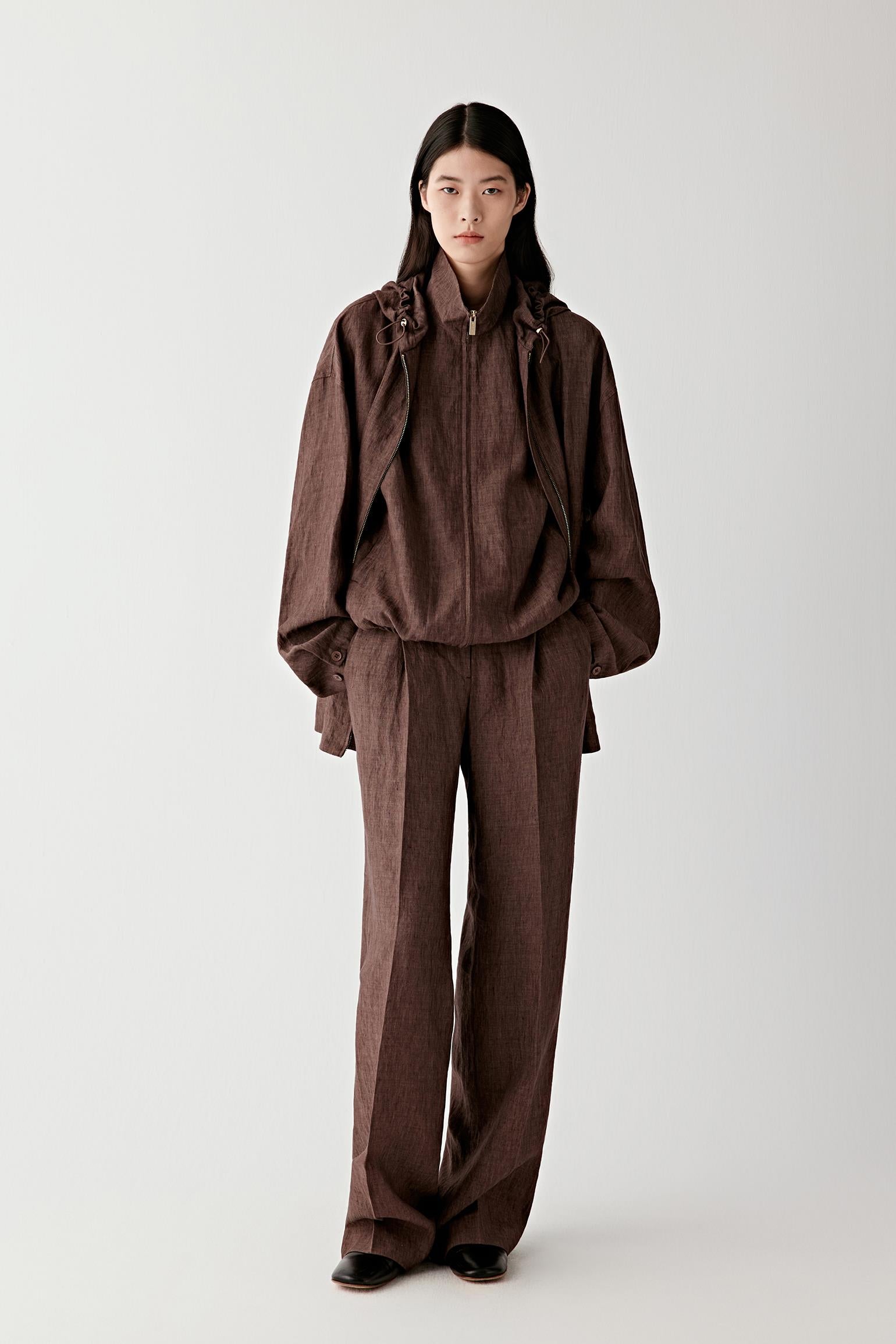 Close-up of the back pocket and upper leg showing seam placement, stitching detail, subtle fading and the natural structure of the lightweight stretch denim fabric