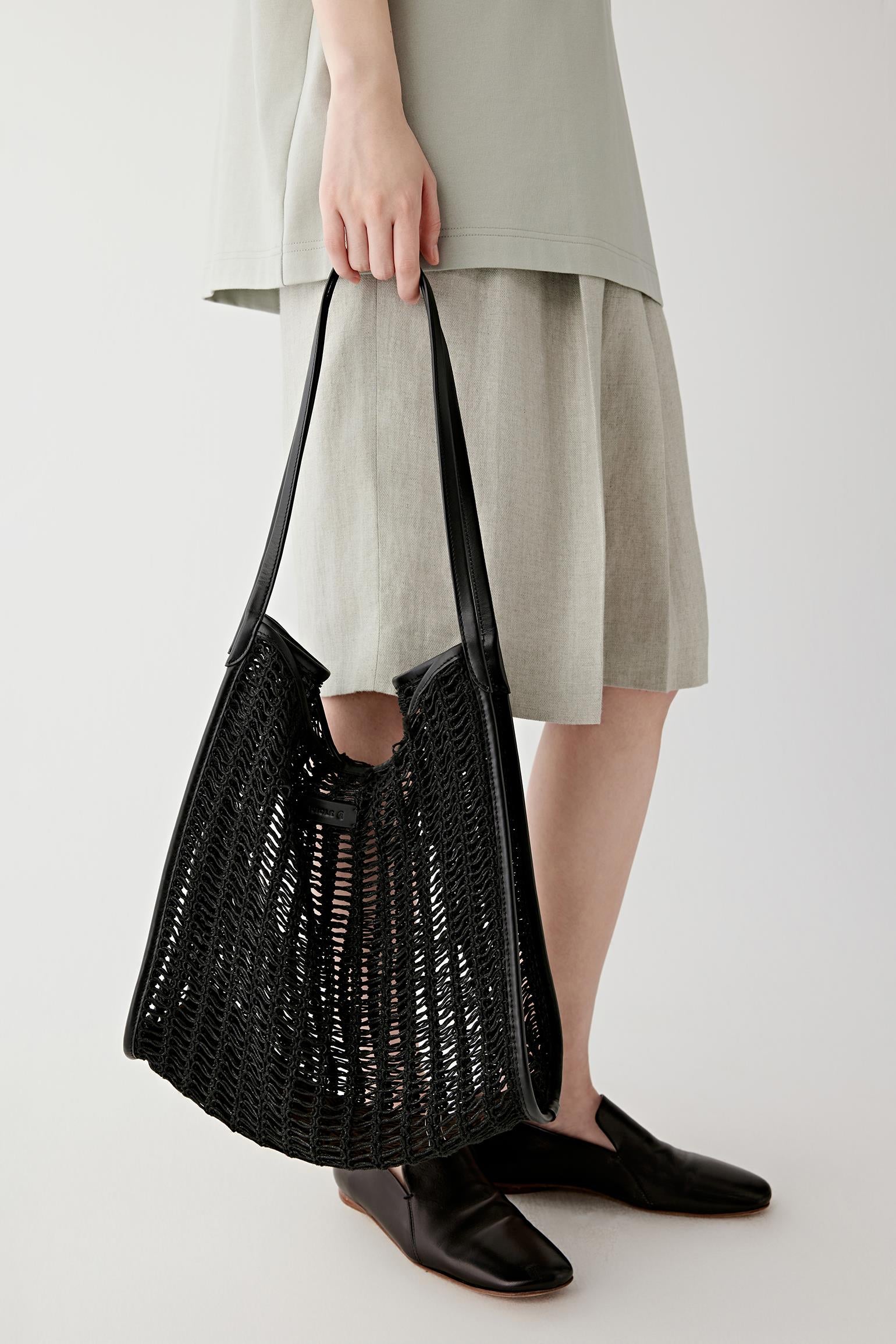 Close-up side angle showing the flexible structure of the bag, open mesh pattern and slight transparency
