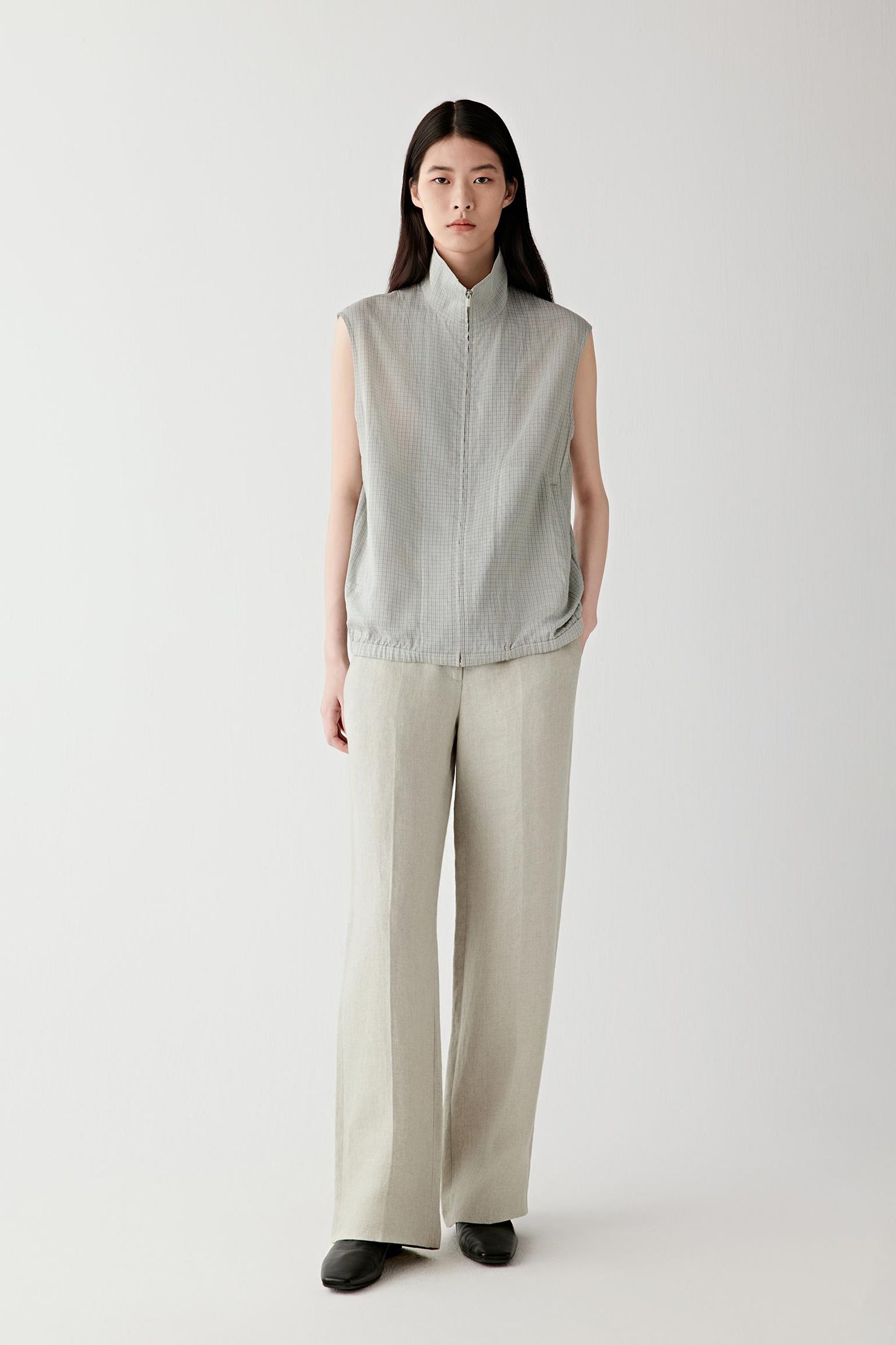 Full-length front view showing the straight silhouette, fitted waistband and elongated proportions. Pressed leg creases create structure and continuity through the silhouette while maintaining fluid movement.