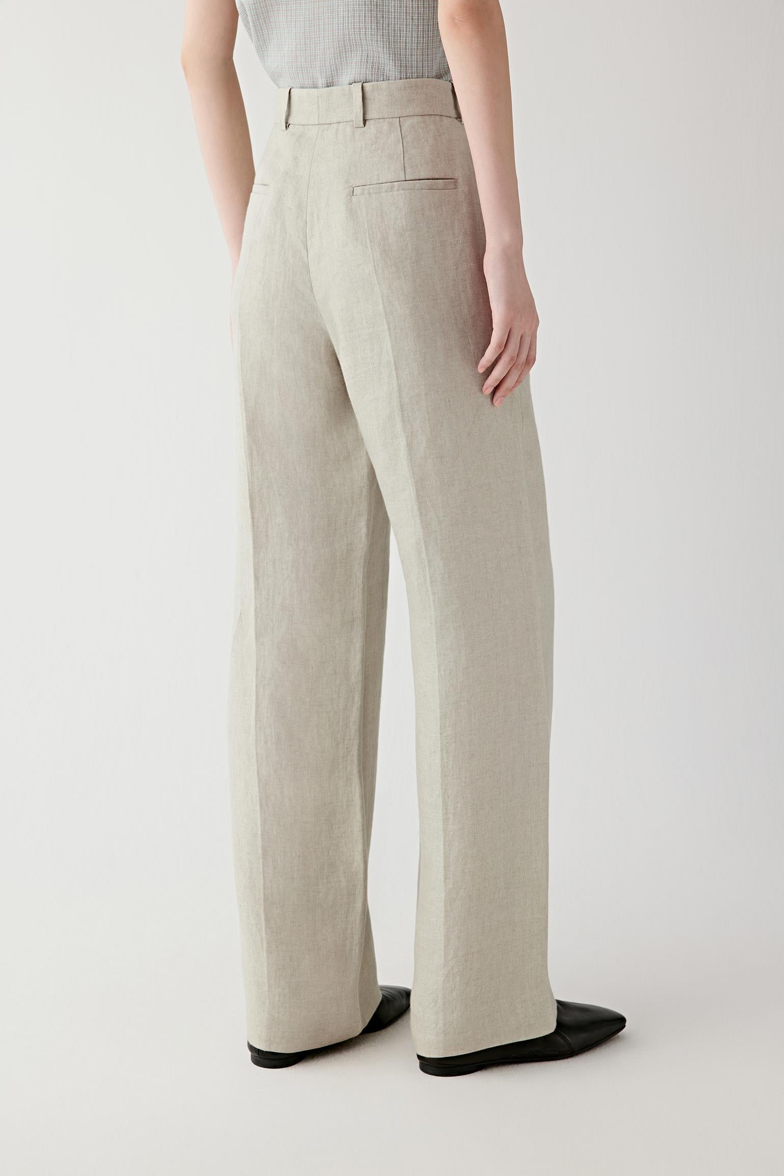 Side or back view emphasizing the clean straight-leg construction and lightly structured drape of the linen twill fabric. The material falls softly while retaining shape and definition.
