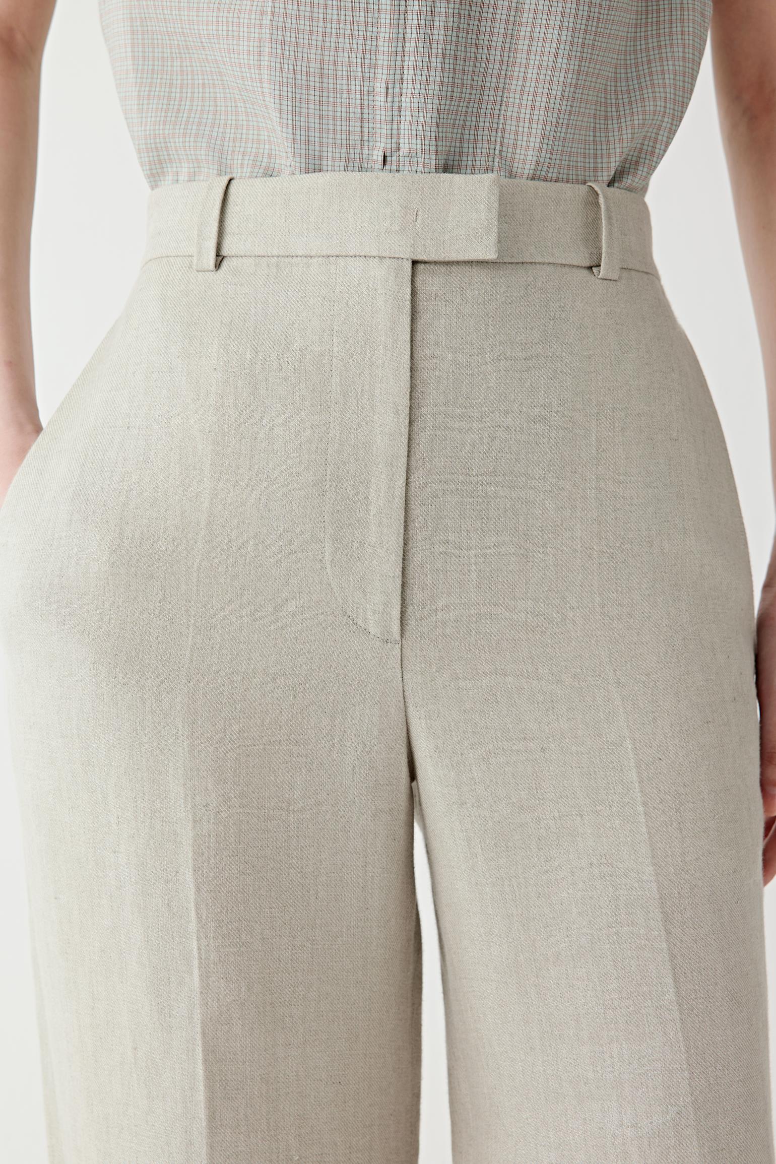 Close-up of the waistband and front fastening detailing the fitted construction, belt loops and concealed closure. The image highlights the compact twill weave and subtle texture of the fabric surface.
