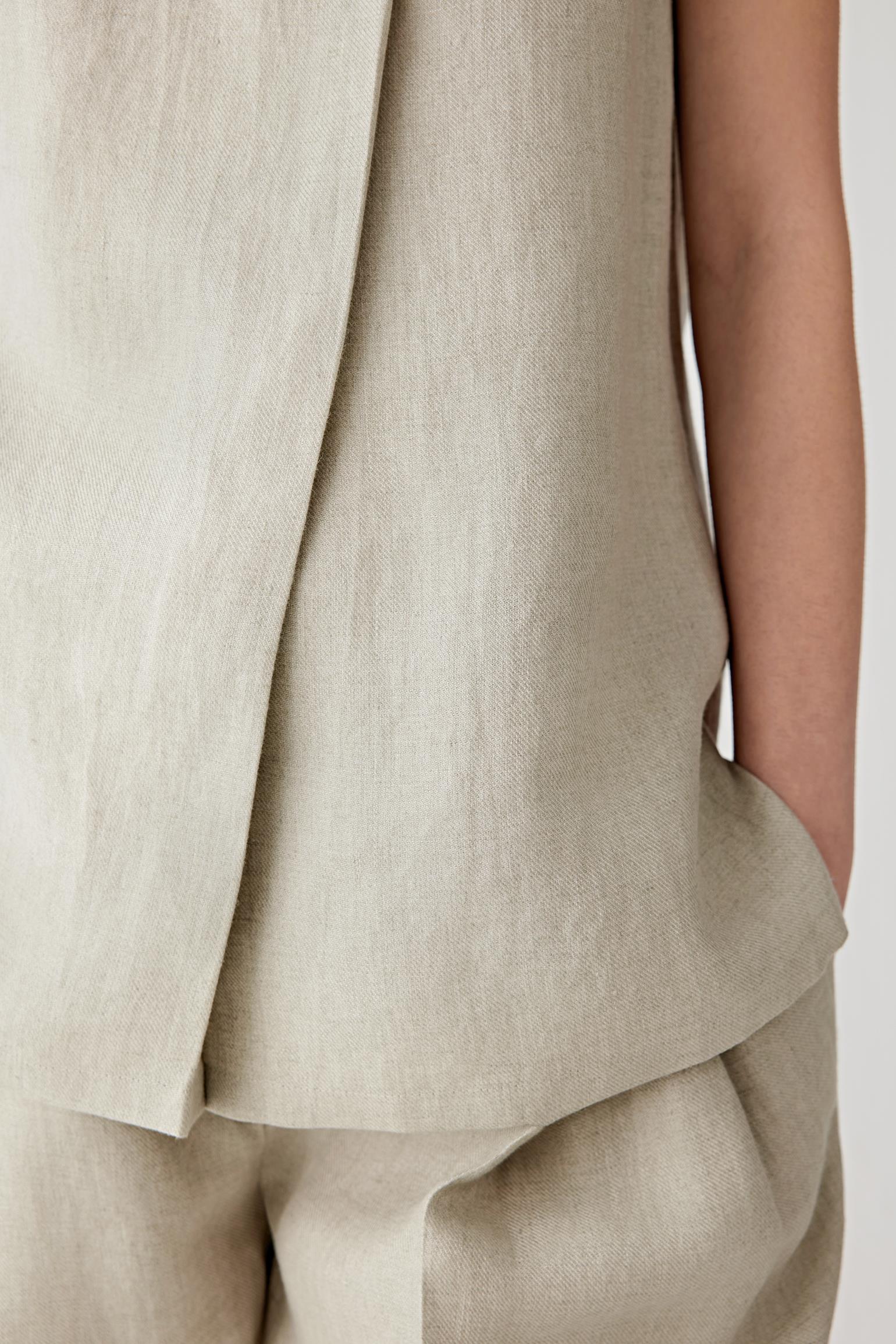 Close-up of the fabric and side slit construction showing the visible twill grain, lightweight weave and softly structured finish characteristic of linen twill.