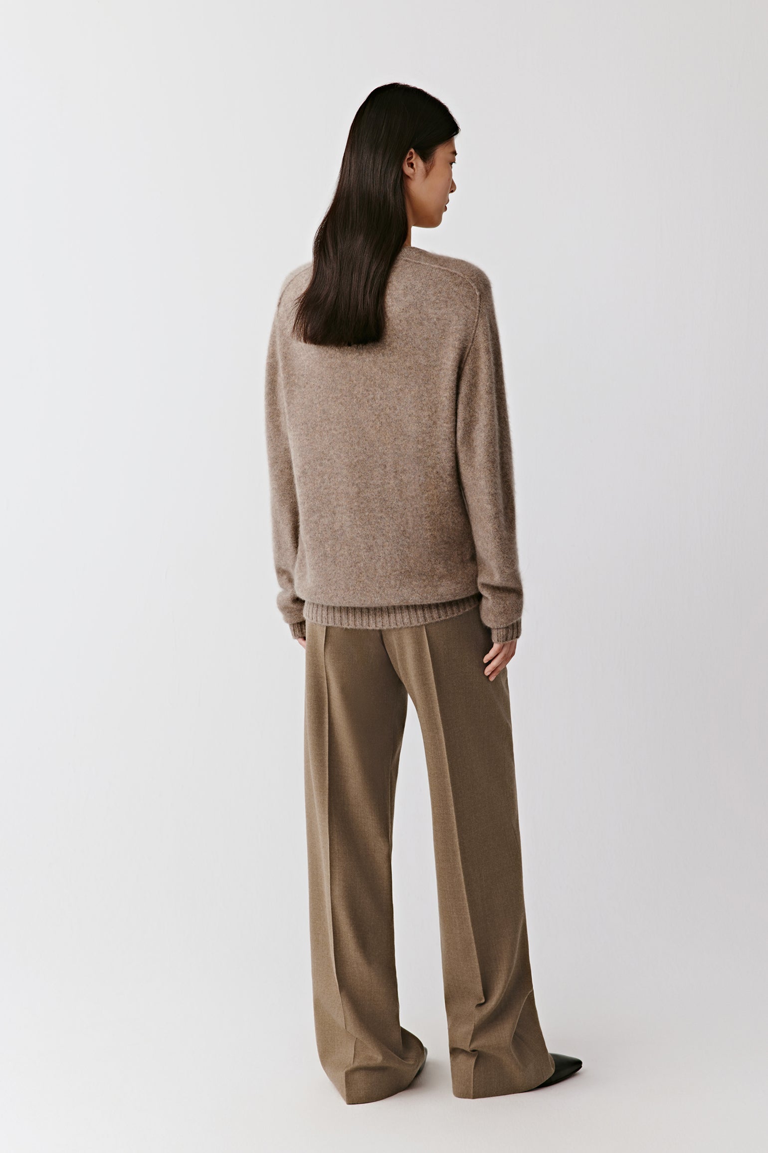 Three-quarter back view capturing the sweater’s clean lines and natural fit across the shoulders.