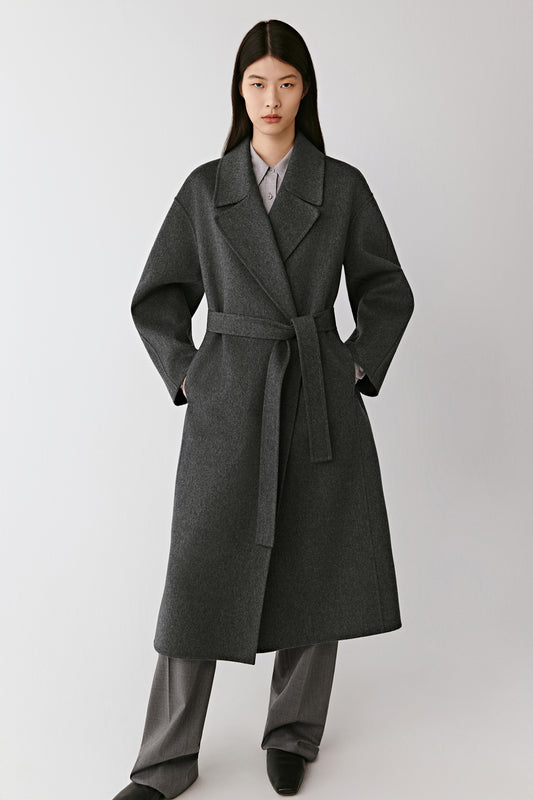 Full-length front view of the model wearing the grey double-faced cashmere coat, showing its relaxed cut and enveloping softness.