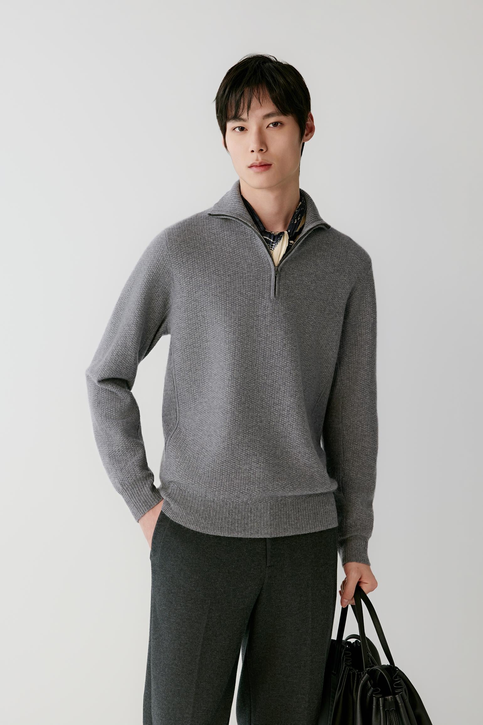 Video Front view of a man wearing a grey cashmere pullover, showing the half-zip funnel neck, long sleeves and straight silhouette.