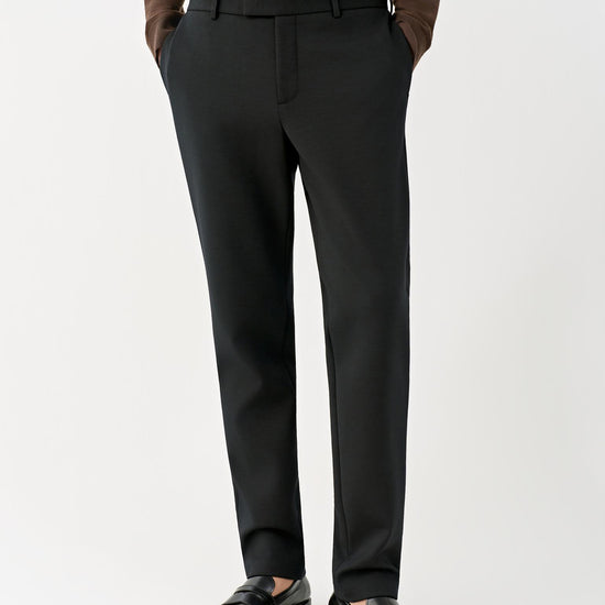 Video Front view of a man wearing deep black slim-leg wool trousers, showing the streamlined silhouette and mid-rise waist.