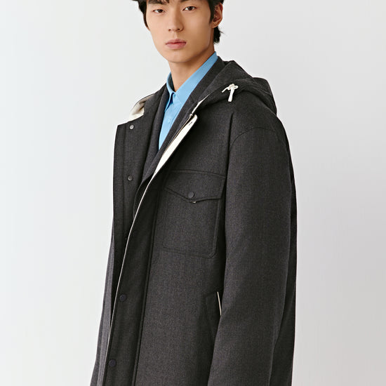 Product video showing a grey quilted wool flannel coat worn on a model, rotating to display the fit, zip fastening, quilted construction, lining, pockets, and overall silhouette from all angles.