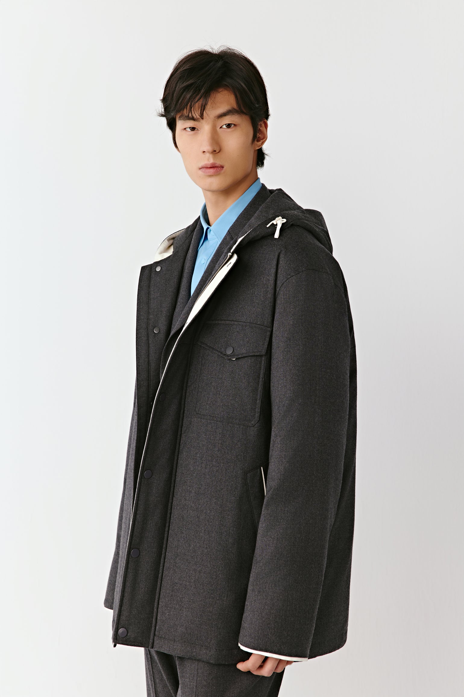 Product video showing a grey quilted wool flannel coat worn on a model, rotating to display the fit, zip fastening, quilted construction, lining, pockets, and overall silhouette from all angles.