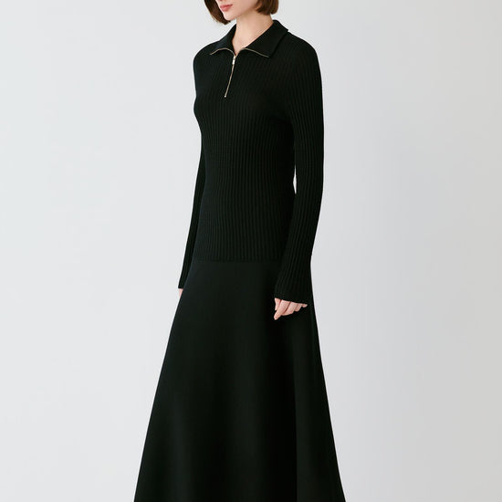 Video Front full-length view of a woman wearing the deep black worsted wool pullover, highlighting the long sleeves and fitted silhouette.