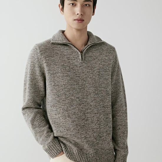 Video Front view of a man wearing a grey melange twisted cashmere cardigan, showing the stand collar, half-zip fastening and straight silhouette.