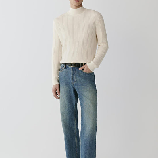 Video Front view of a man wearing a white cashmere pullover, showing the mock neck, long sleeves and textured cable knit.