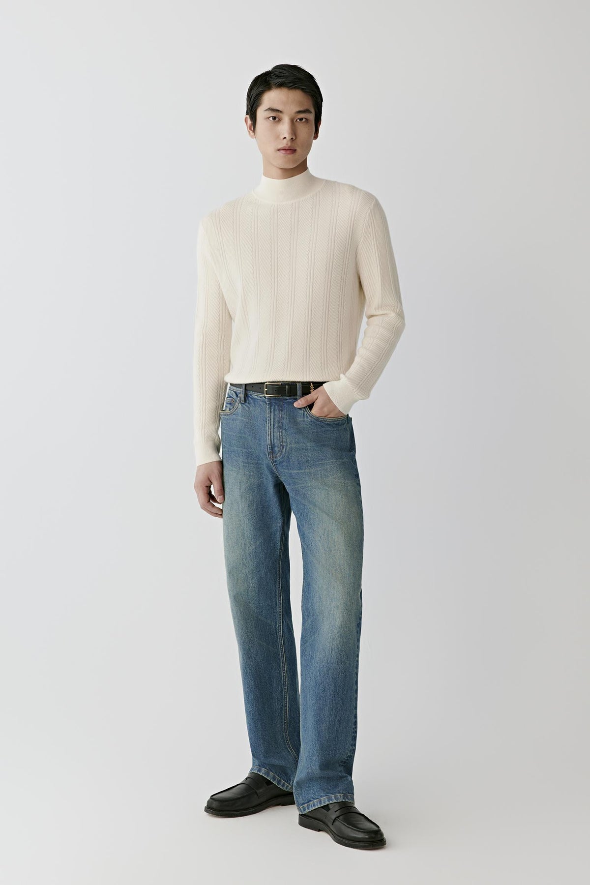Video Front view of a man wearing a white cashmere pullover, showing the mock neck, long sleeves and textured cable knit.