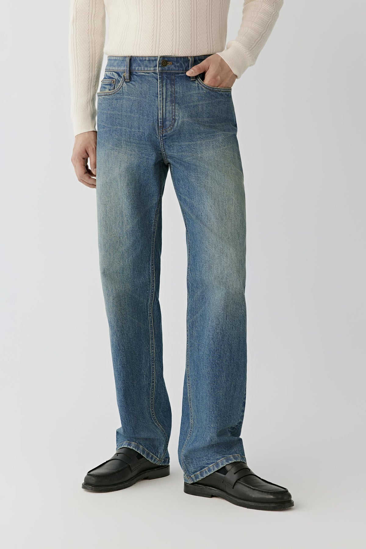 Video Front view of a man wearing blue denim jeans, showing the low-rise waist and loose-leg silhouette.