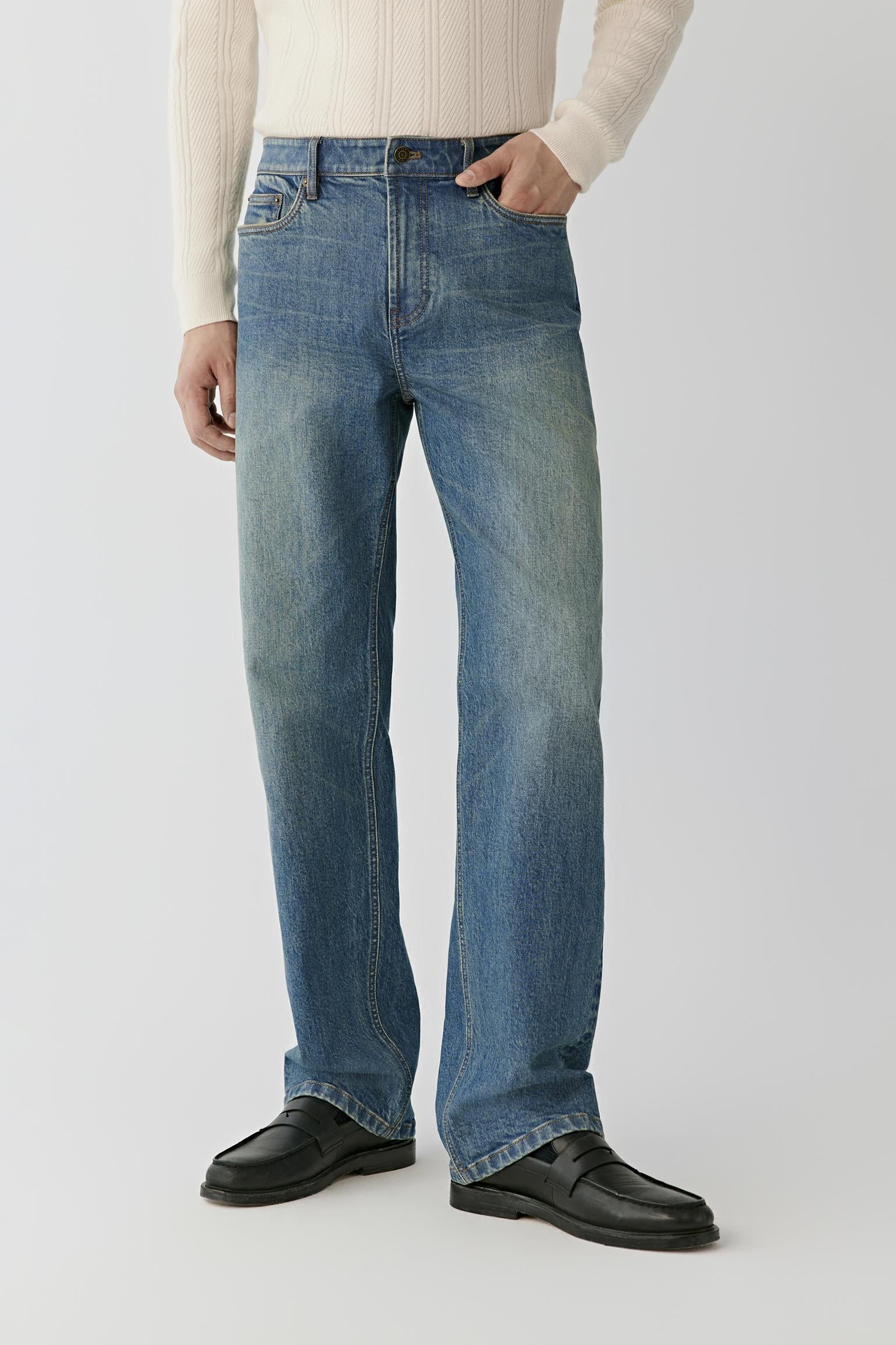 Video Front view of a man wearing blue denim jeans, showing the low-rise waist and loose-leg silhouette.