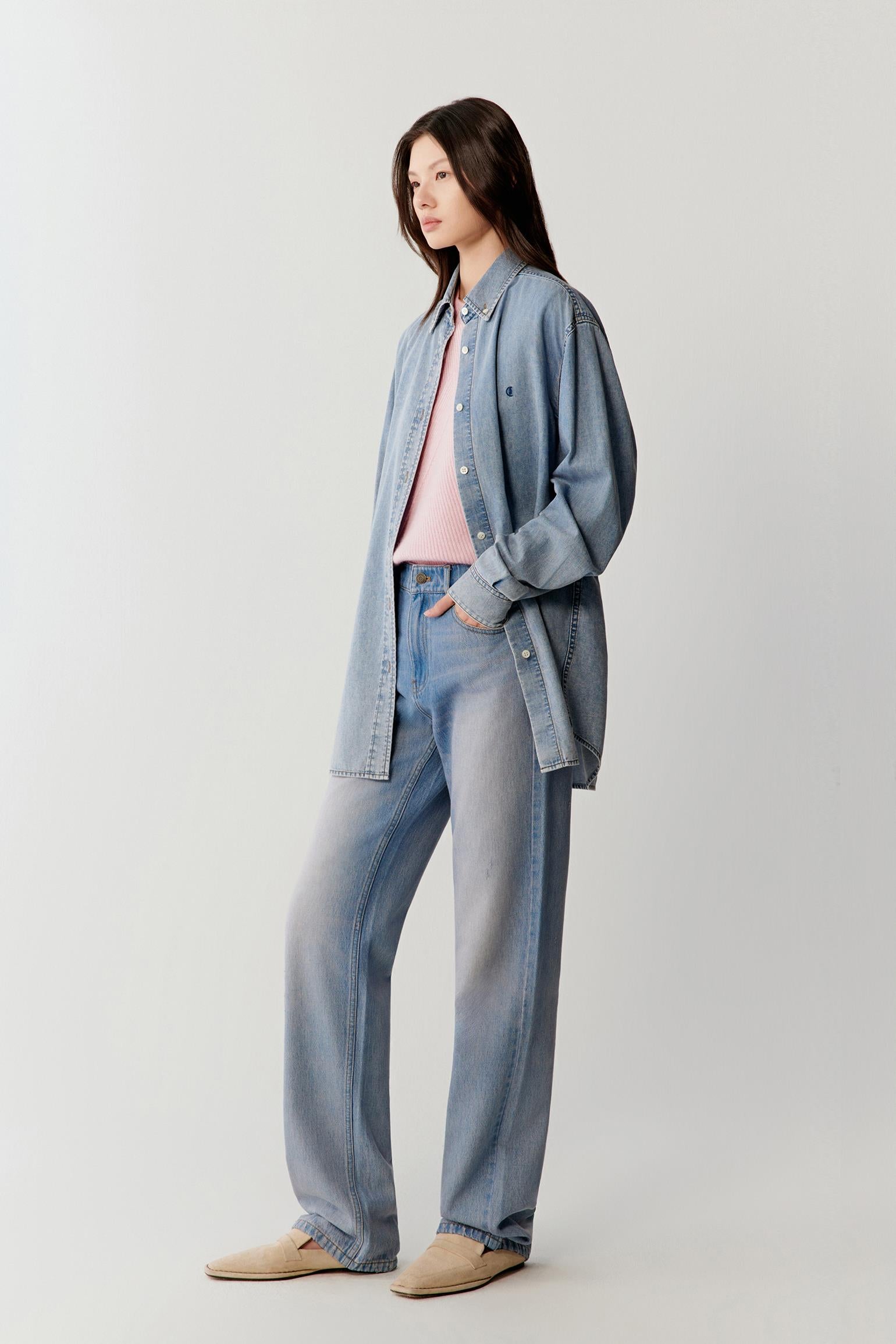 Video showing the model walking in a coordinated denim outfit, emphasizing the fluid movement of the cotton denim shirt, the soft structure through the shoulders and sleeves, and the relaxed silhouette in motion