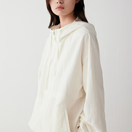 Video showing the model walking in a straight line and slight turn, highlighting the relaxed cut of the jacket, the loose fit through the body, the dropped shoulder line, the way the fabric moves fluidly without stiffness, the gentle expansion created by the gathered hem and the natural movement of the hood and sleeves with each step