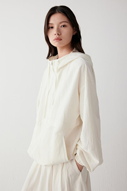Video showing the model walking in a straight line and slight turn, highlighting the relaxed cut of the jacket, the loose fit through the body, the dropped shoulder line, the way the fabric moves fluidly without stiffness, the gentle expansion created by the gathered hem and the natural movement of the hood and sleeves with each step