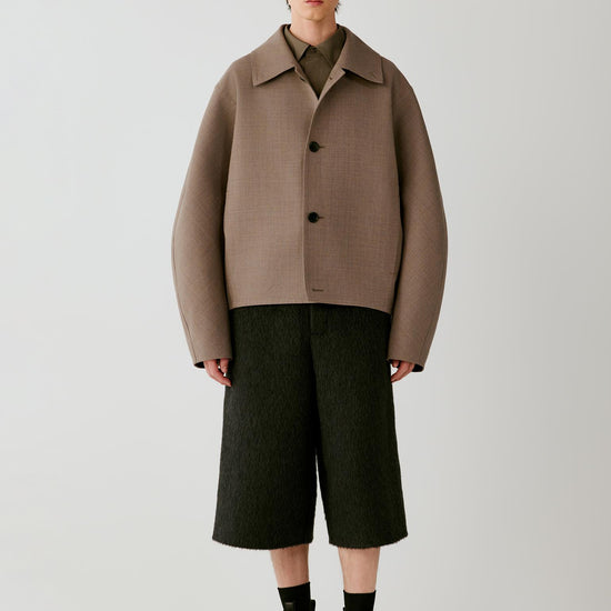Video of a man wearing a taupe melange wool and silk jacket, showing the movement of the cropped silhouette and structured double-face fabric.
