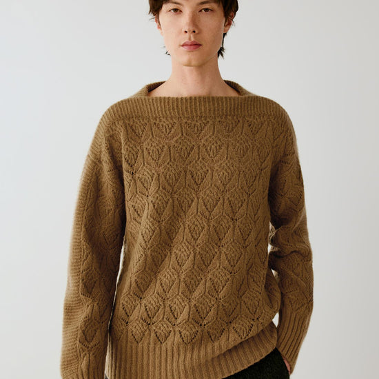 Video of a man wearing a dark mustard yellow silk, cashmere and alpaca pullover, showing the relaxed silhouette and movement of the openwork knit as he moves.