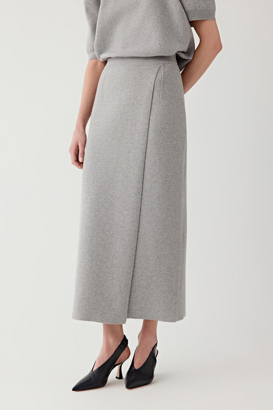 Video showing the model walking and turning while wearing the wool and cashmere skirt. The sequence highlights the structured knit fabric and the steady drape of the garment as it moves with the body. The long silhouette remains balanced and fluid, while the soft wool and cashmere fibres allow gentle movement without losing shape.