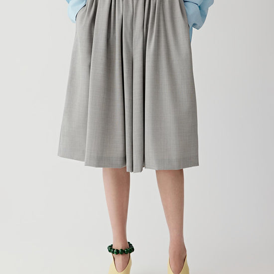 Woman wearing a light blue shirt and gray short on a white background