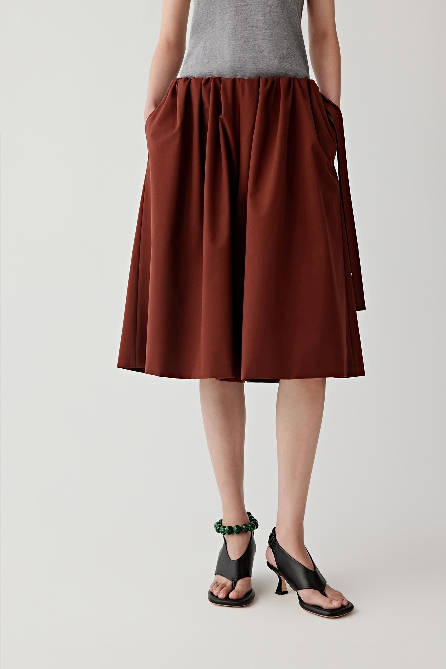 Video showing the model walking and turning while wearing the shorts, revealing the fluid movement of the fabric and the relaxed silhouette.