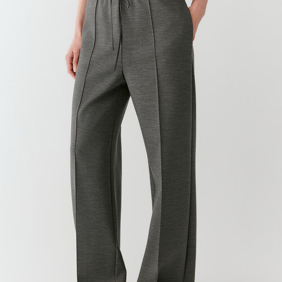 Video of a woman wearing dark grey melange Ponte wool trousers, showing the straight-leg silhouette and movement of the fabric as she moves.