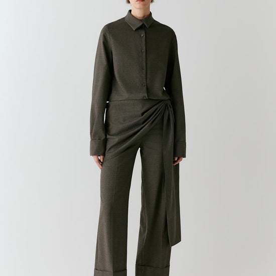Video of a woman wearing a medium grey melange wool suiting shirt, showing the relaxed silhouette and fluid movement of the fabric.