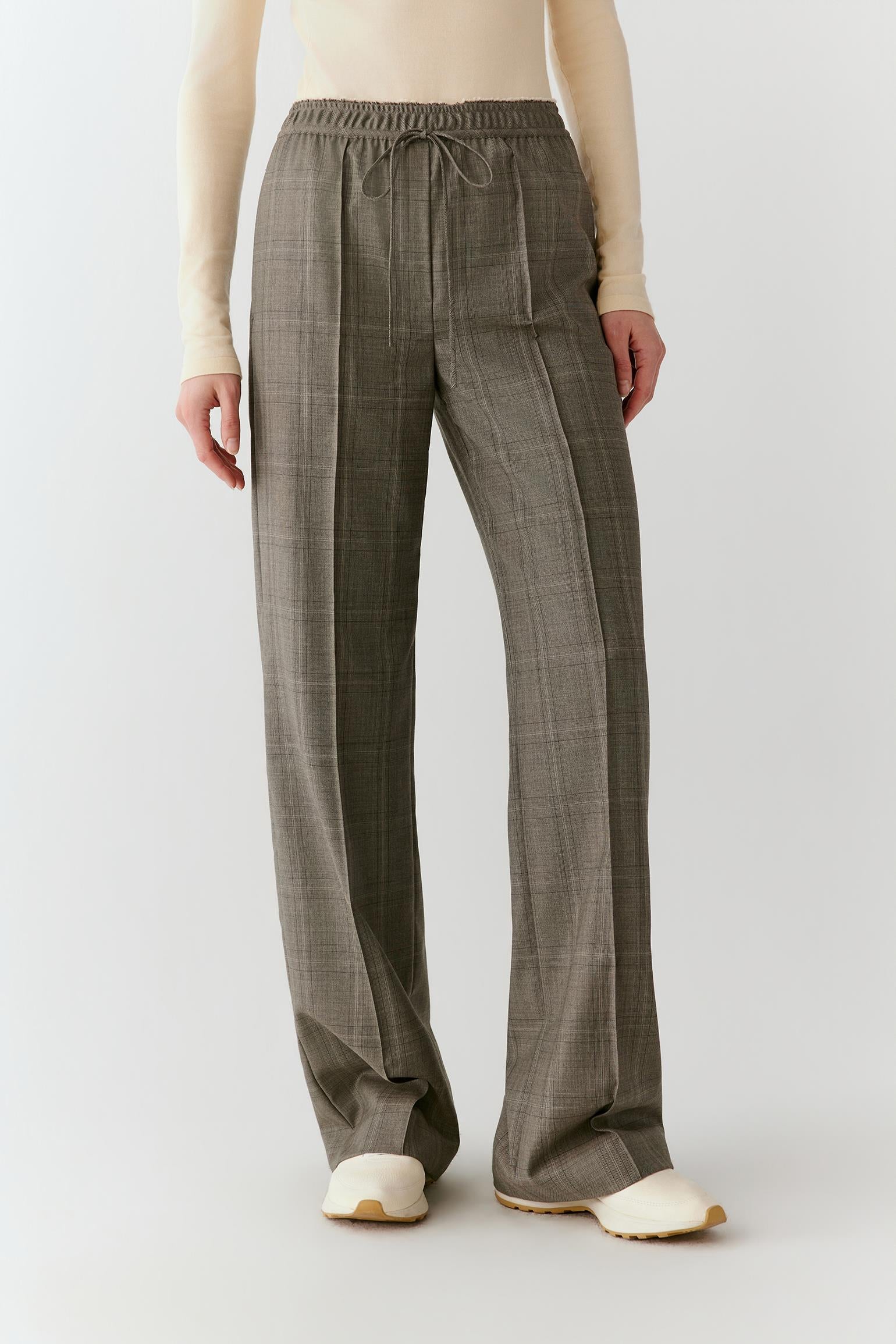 Video of a woman wearing Glen plaid trousers, showing the movement of the straight-leg silhouette and fluid drape as she walks.