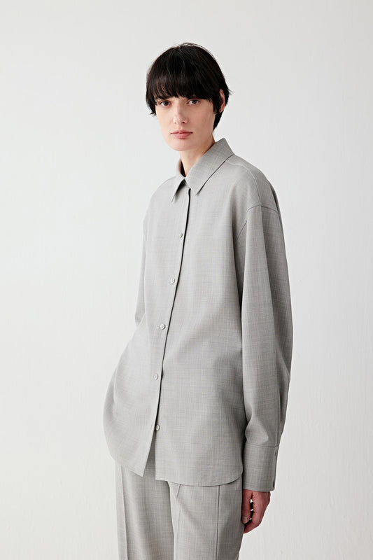 Video of the woman walking in the light grey twist wool shirt and trousers, showing the fluid drape in motion.