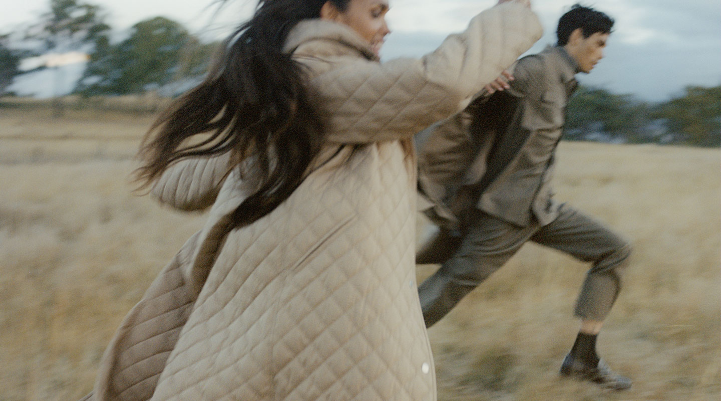 man and woman running in field